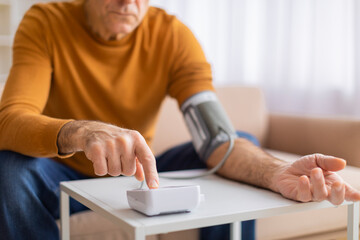 Man measuring blood pressure with digital monitor