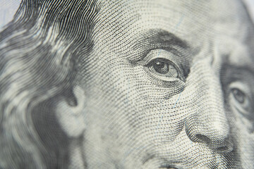 A close-up of US President Benjamin Franklin's face on the 100 US dollar bill