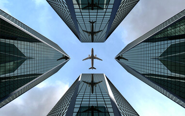 Bottom view airplane flying over high rise office buildings and reflects in glass modern facades....