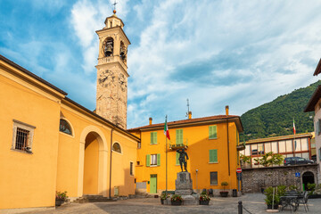 Medieval town square with church Chiesa Santo Stefano and colorful buildings in Lenno comune on...