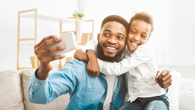 Young father with little daughter taking selfie