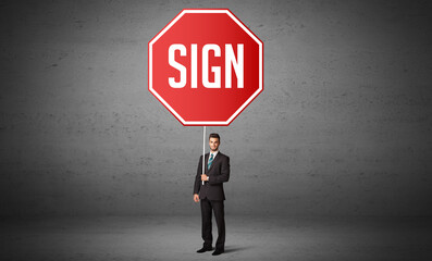 Young business person holding road sign