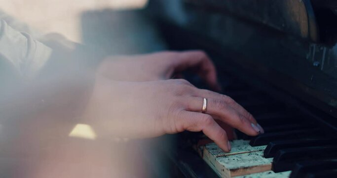 Man's hands play on burnt piano keys. A burnt piano. Man's hands on the piano.