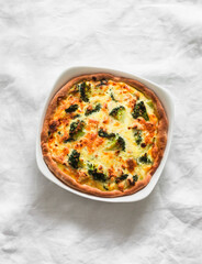 Quiche with broccoli, chicken, spinach and cheese on a light background, top view