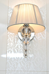 Elegant classic style lamp as a bathroom decoration detail. Warm light.