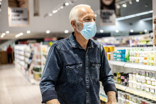 Man Grocery Shopping At The Supermarket Wearing A Facemask. Caucasian Man Grocery Shopping At The Supermarket Wearing A Face Mask To Avoid The Virus While Pushing The Cart, Lifestyle Concepts.