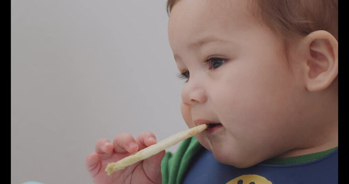 Baby boy chewing on a teething cracker