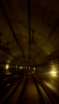 Time lapse, POV view on train riding in the subway tunnel, Vertical video. Hyperlapse of automatic train moving to tunne