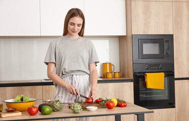 Young woman cooking dinner in modern loft style kitchen interior