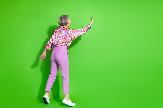Full length photo of excited smiling woman wear print shirt arm palm touching empty space isolated green color background - Powered by Adobe