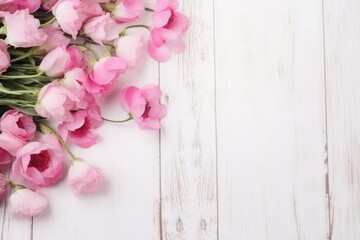 Fototapeta na wymiar A cascade of delicate pink ranunculus flowers across a bright white wooden background. Pink Ranunculus Flowers on White Wooden Surface