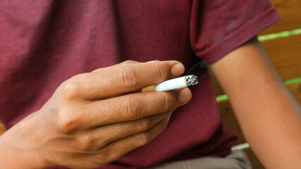 A man relaxing and smoking a cigarette. Smoking is not good for health. Stop smoking.