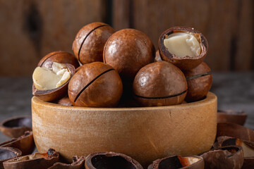 Macadamia nuts in wooden cup on table,