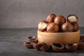 Macadamia nuts in wooden cup on table with copy space