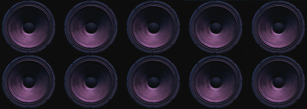 Close-up of speakers membrane on black background with colored lighting.