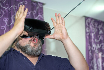 Overweight man with beard amazed while contemplating virtual reality at VR