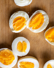 Close-up of sliced boiled eggs arranged neatly on a wooden cutting board
