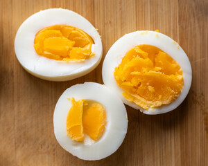 Close-up of sliced boiled eggs arranged neatly on a wooden cutting board