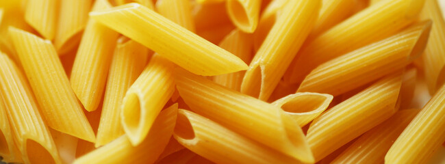 Penne pasta texture banner. Italian cuisine. Food background. 