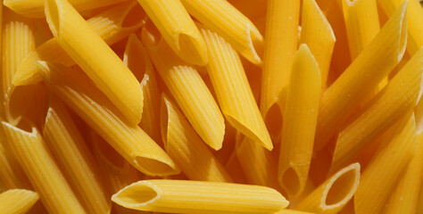 Penne pasta texture. Italian cuisine. Food background. 