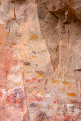 Vertical image of colourful animal rockpaintings and handprints on rock walls at Cueva de las Manos, UNESCO World Heritage Site, Patagonia, Argentina