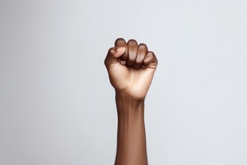 A raised clenched fist, symbolizing strength, resistance, and solidarity, set against a plain white...