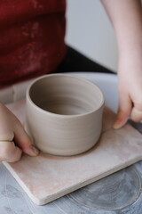 Person doing pottery in a studio. Vertical.