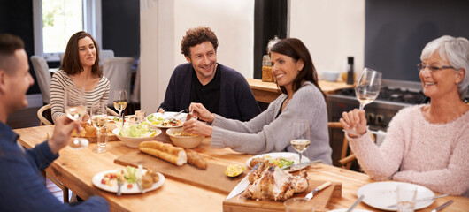 Bonding, eating and family at dinner in dining room for party, celebration or event at modern home. Smile, happy and group of people enjoying meal, supper or lunch together with wine at house.