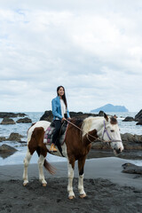 Tourist woman ride a horse beside the sea beach - 762413111