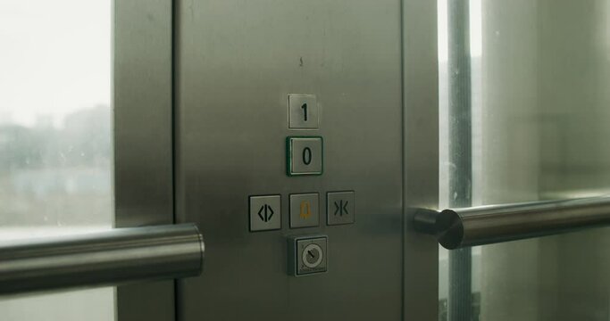 A woman presses the floor selection button in an elevator, close-up of her hand, an unrecognizable person