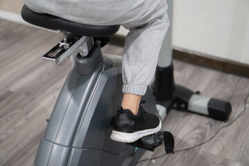 Woman using elliptical cross trainer in gym modern fitness center room