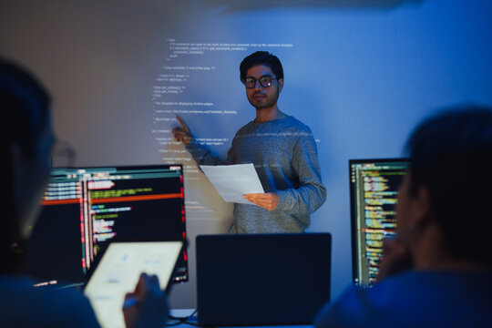 asian and Indian developer team brainstorming and presentation about  ai coding project at night in office