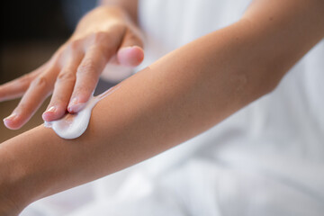 putting hand and body lotion cream on hand