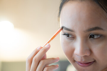Woman doing makeup eyebrow pencil
