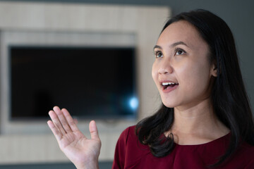 Image of happy young lady standing in front of television