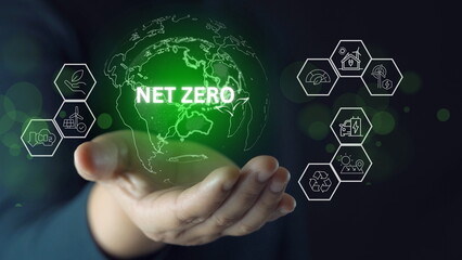 Businessman holding globe with net zero icon on virtual screen.Net zero and carbon neutral concept....