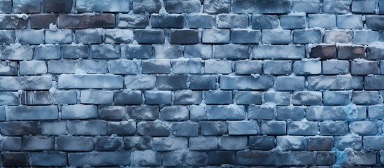 An electric blue brick wall with a dusting of snow on it, showcasing the intricate pattern of the grey rectangle bricks in the buildings stone wall