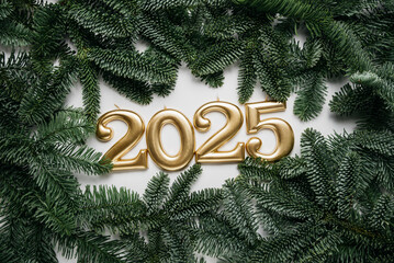 Holiday background Happy New Year 2025. Numbers of year 2025 made by gold candles on background with fir tree. celebrating New Year holiday, close-up. Space for text