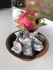 Fototapeta na wymiar Delicious white pitaya cut into cubes in wooden bowl
