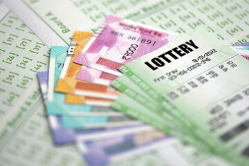 Green lottery tickets and indian rupees money bills on blank with numbers for playing lottery close up
