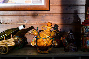 Clay jugs of wine on a wooden shelf in the sunset