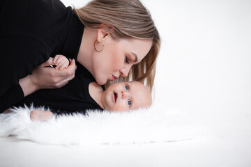 A beautiful girl in black golf kisses her two momth old baby