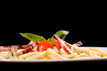 Pici senesi alla checca or Pici pasta from Siena Tuscany with mozzarella, basil, cherry tomatoes  and Tuscany lonza salami