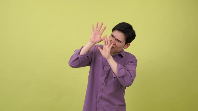 The Asian man was frightened and covered his face with his hands because he was being bullied
