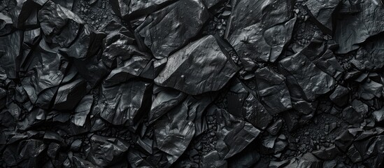 A detailed shot of a stack of dark charcoal showcasing a monochrome pattern resembling automotive tires, mixing metal, wood, and soil textures in a dark and mysterious setting