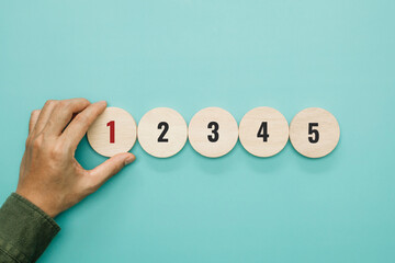 A man hand place wooden cubes with number one. Priority of activities. Concept of task priority and...