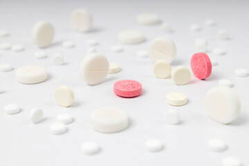 Closeup of pink and white round pills on white background
