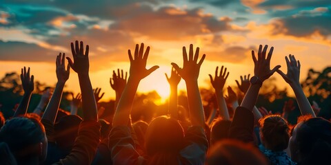 Silhouettes of people raising hands in worship against an autumn sunset backdrop. Concept Autumn Sunset, Silhouettes, Worship, People, Raising Hands