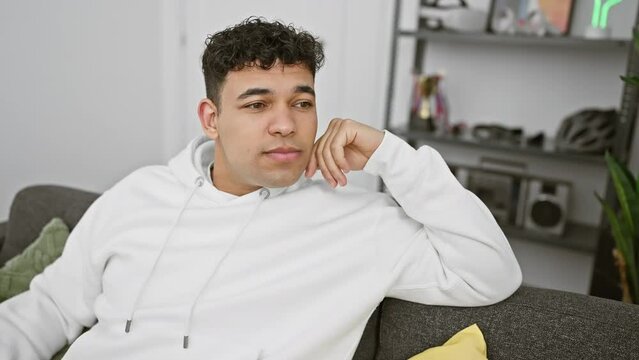 Cheerful, confident young arab man, clad in casual attire, beaming a natural smile, cheerfully laughing away in his cozy home.