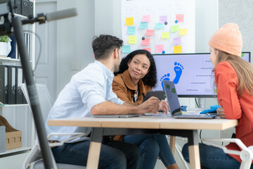 Multiethnic startup business team on meeting in modern bright office interior brainstorming, working on laptop and tablet computer